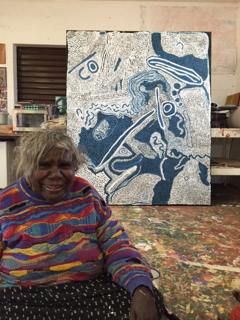 Mrs. E. Giles sitting in front of one of her paintings