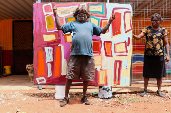 A photo of artist Bob Gibson in front his painting.